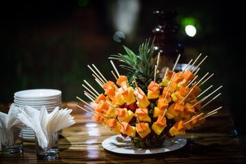 Fruit kebabs poking into a pineapple